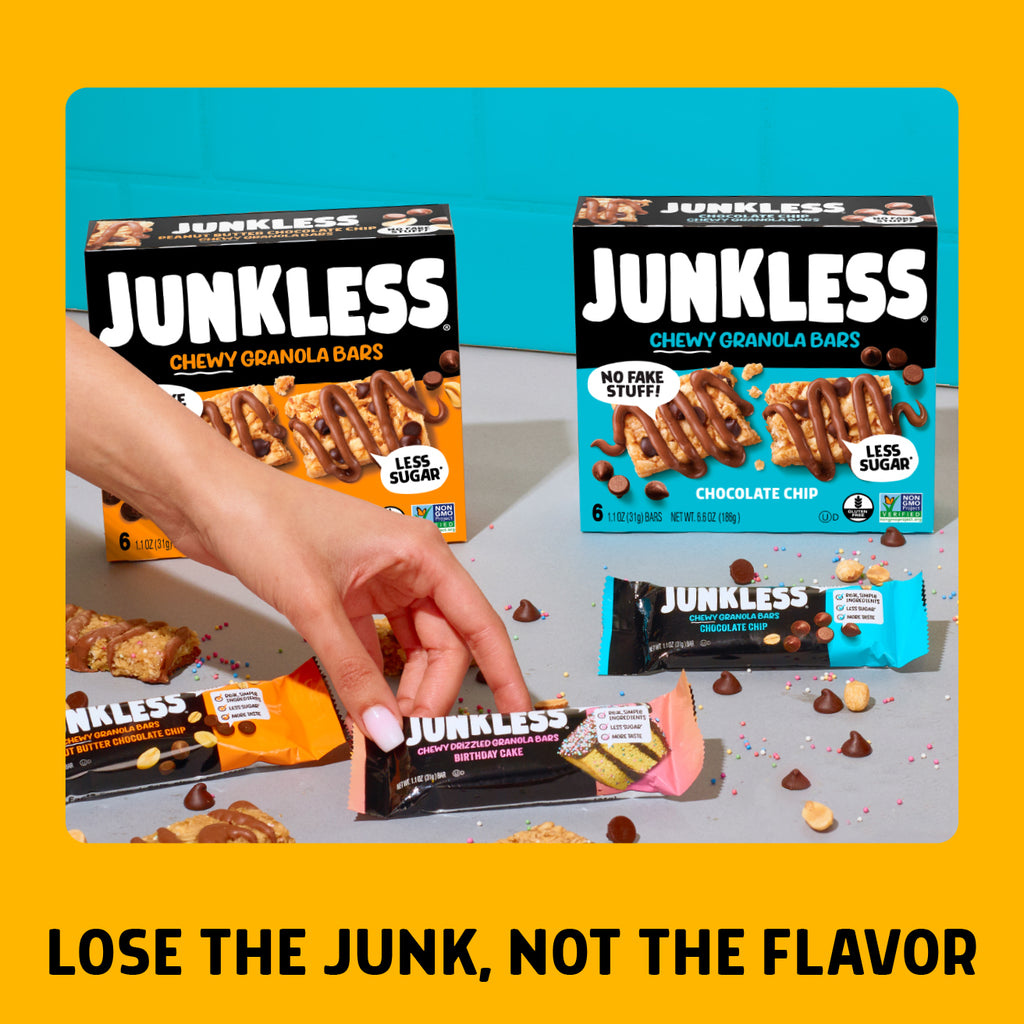 Junkless chewy granola bars packaging with a hand holding a bar on a gray surface.