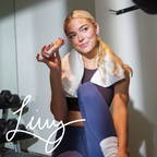 Woman in workout attire holding a snack bar with 'Livvy' branding in a gym setting.