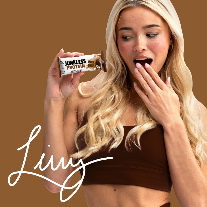Woman holding a Junkless Protein bar with a brown background