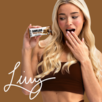 Woman holding a Junkless Protein bar with a brown background