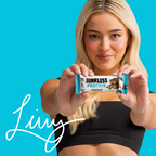 Woman holding a Junkless Protein bar against a blue background