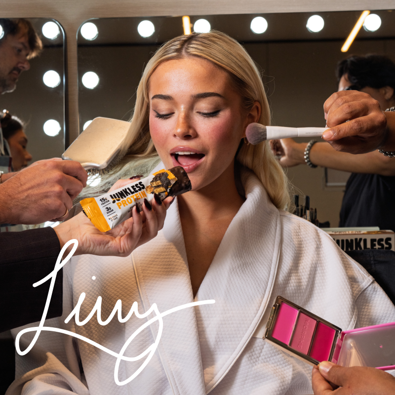 Woman getting makeup applied in a mirror with 'Livvy' branding.
