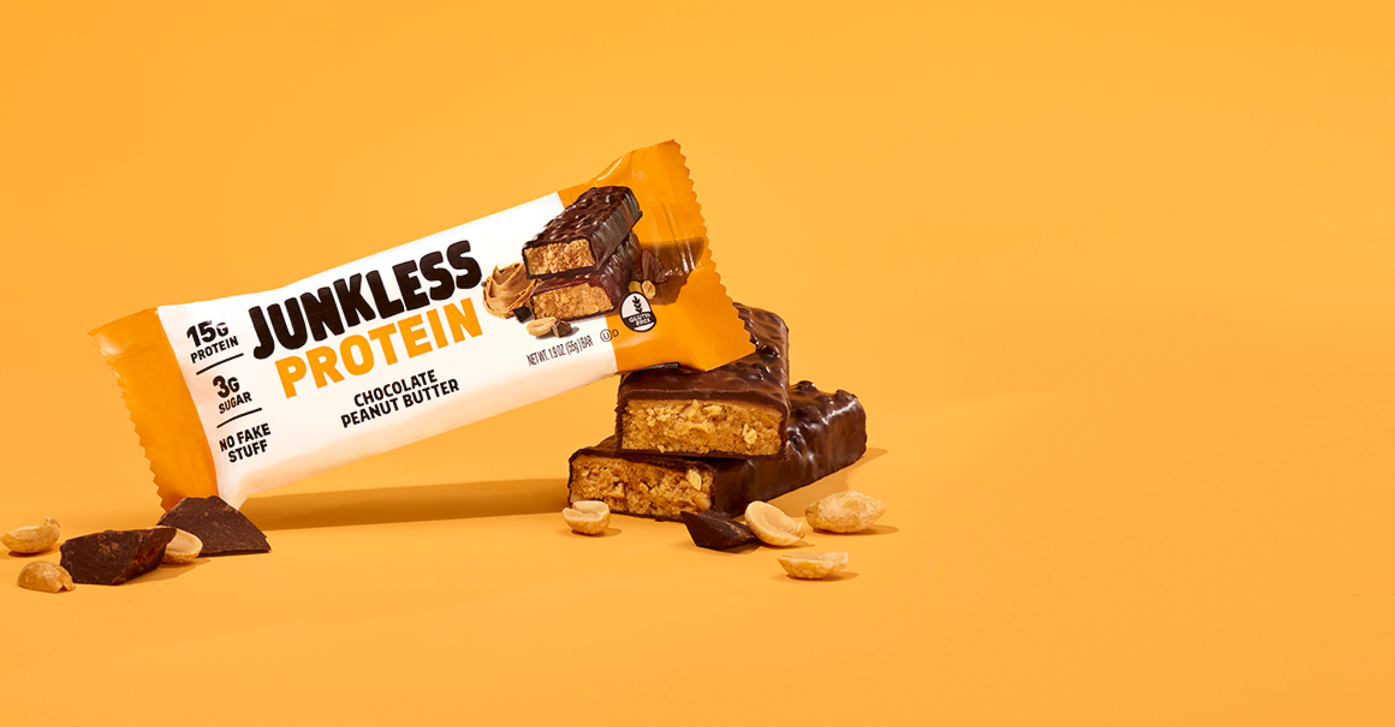 Junkless Protein bar with chocolate and peanut butter flavor on an orange background