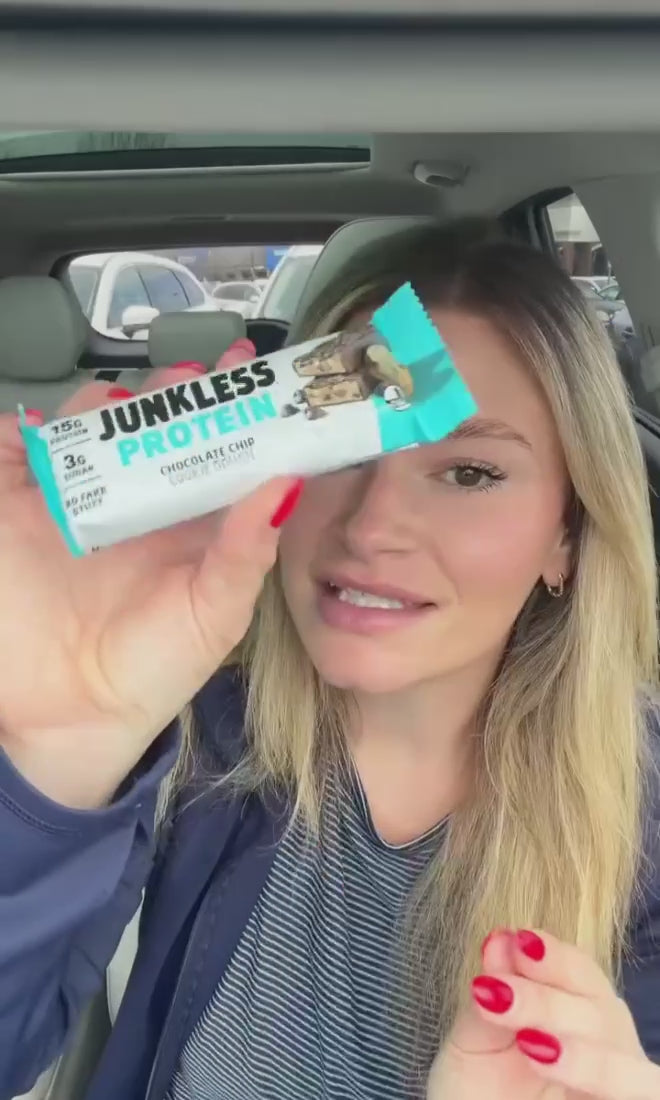 women holding a protein bar in her car
