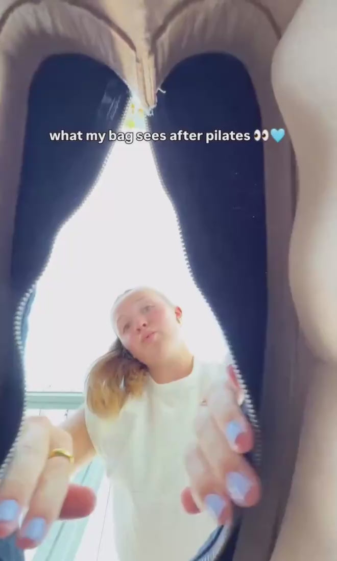a girl opening a bag with her face in the frame